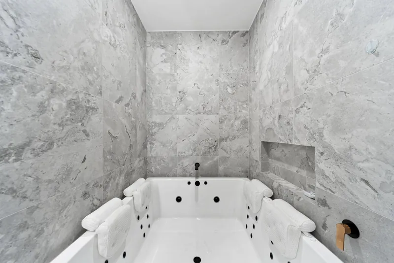 Spa bath with a tiled surround and wall niche in Craigburn Farm