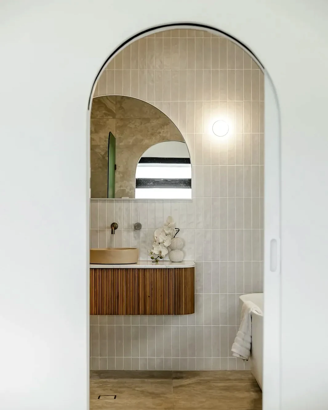 Arched doorway into a tiled bathroom with a floating timber vanity, Bellevue Heights