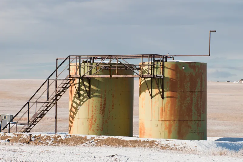 Weathered tanks with a stairway on a snowy lease