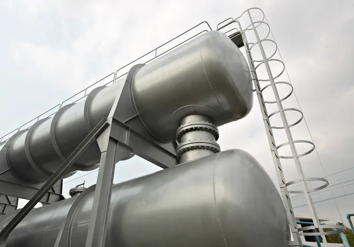 Horizontal steel tanks and a ladder seen from below