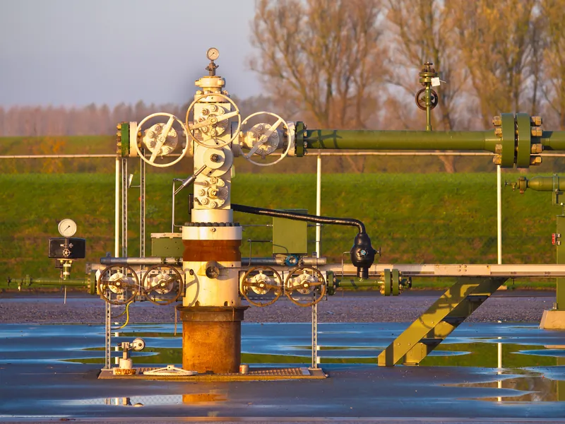 Wellhead with gauges and valves in a green field