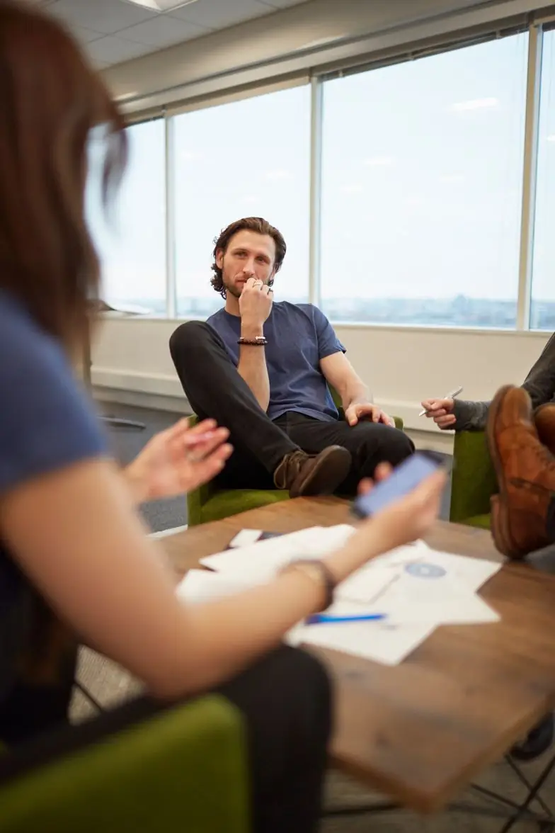 A founder seated in a modern office, thinking through a discussion