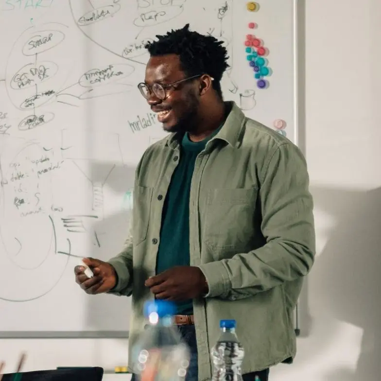 Team member presenting at a whiteboard in a meeting room