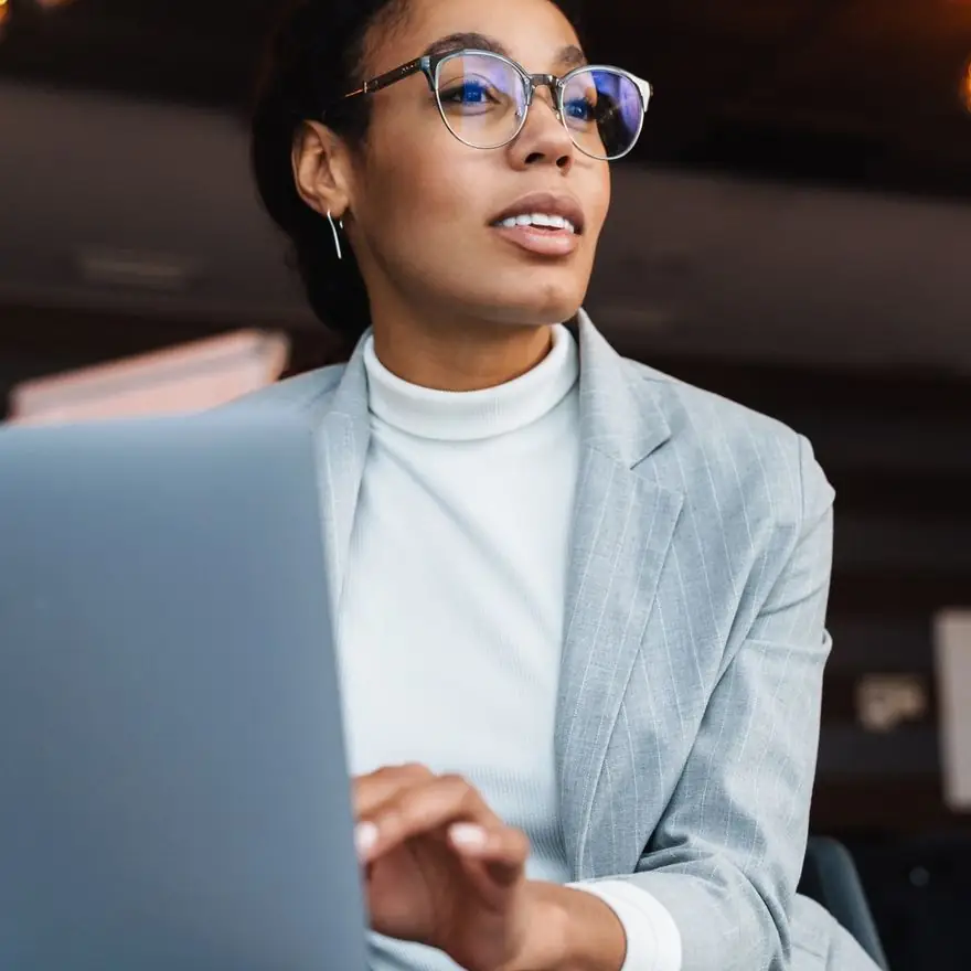 Operations leader with glasses working at a laptop