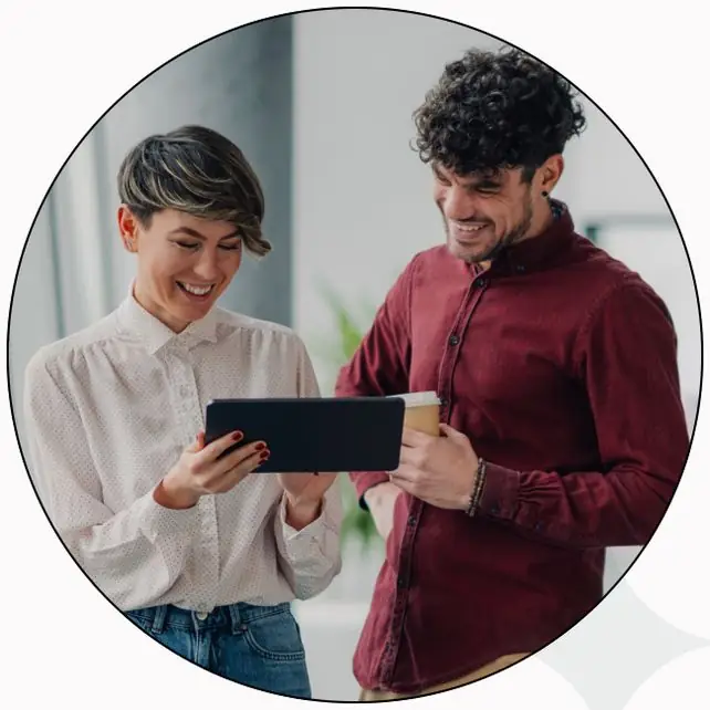 Two colleagues laughing over a tablet