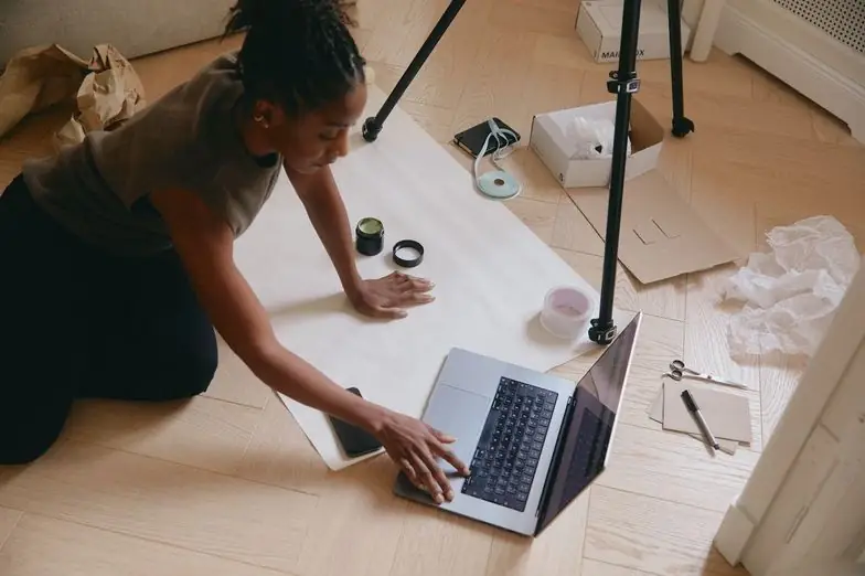 Overhead view of a woman working on a MacBook in a studio