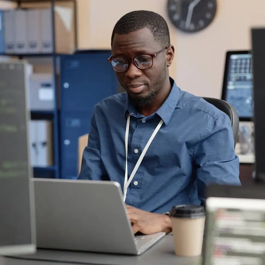 Engineer with glasses working at a laptop in an office