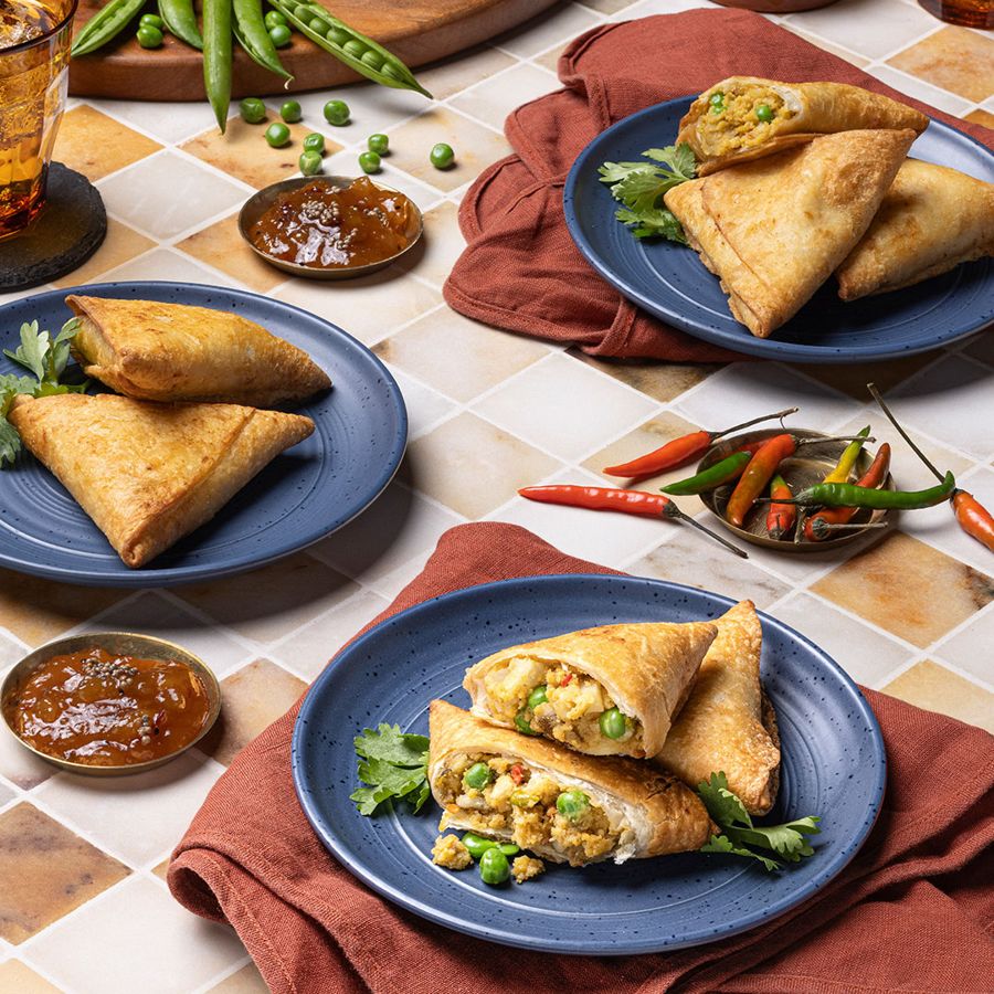 Your Nana's Kitchen vegetable samosas plated with chutney and fresh chilies