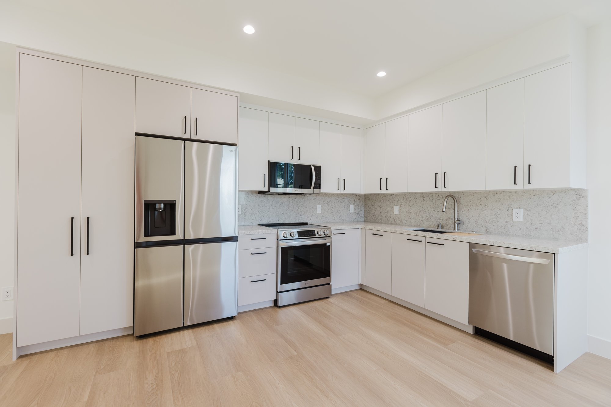 Kitchen with a pale island and tall timber cabinetry.