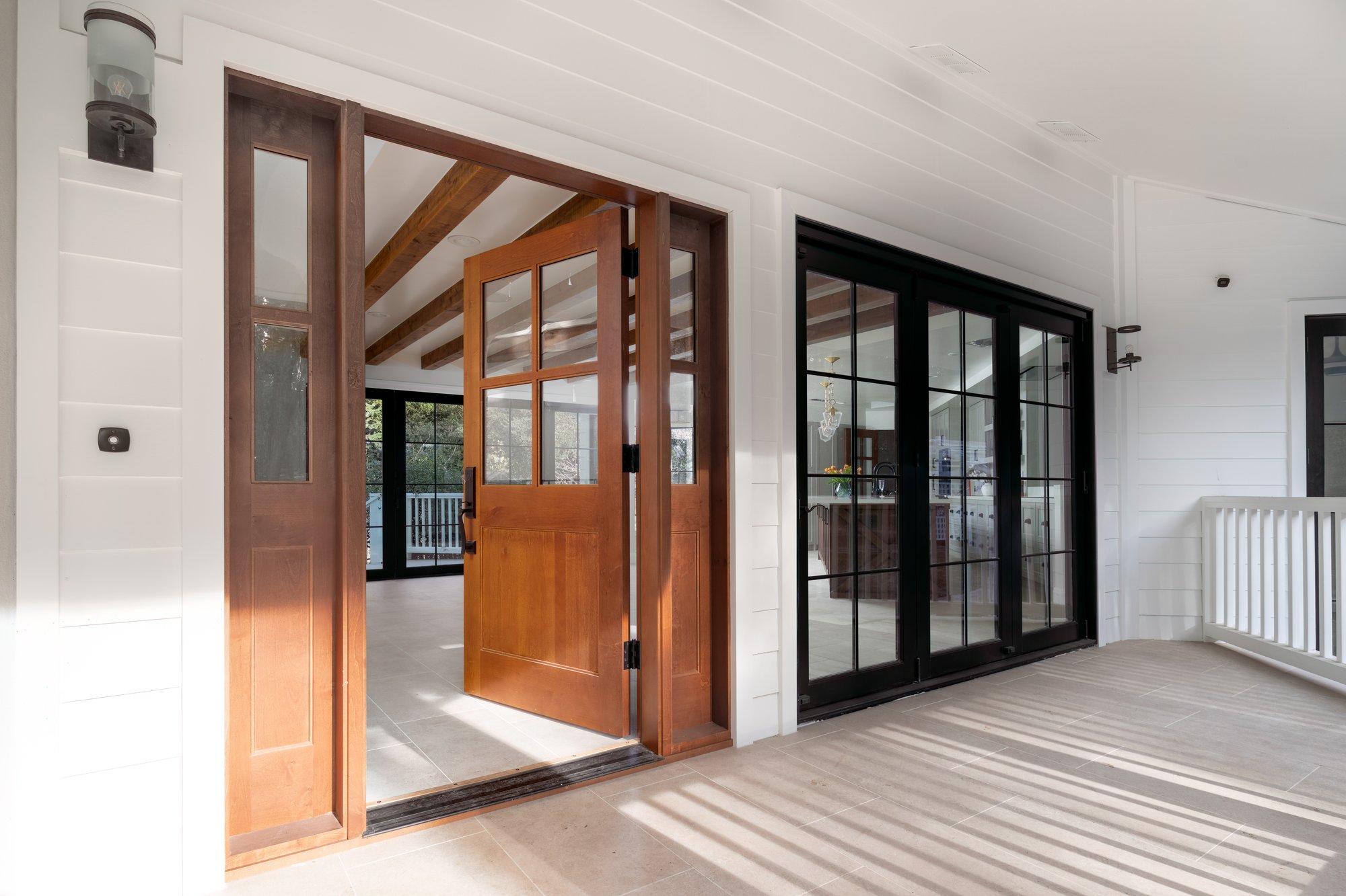 Entry framed by timber doors and black-framed windows.