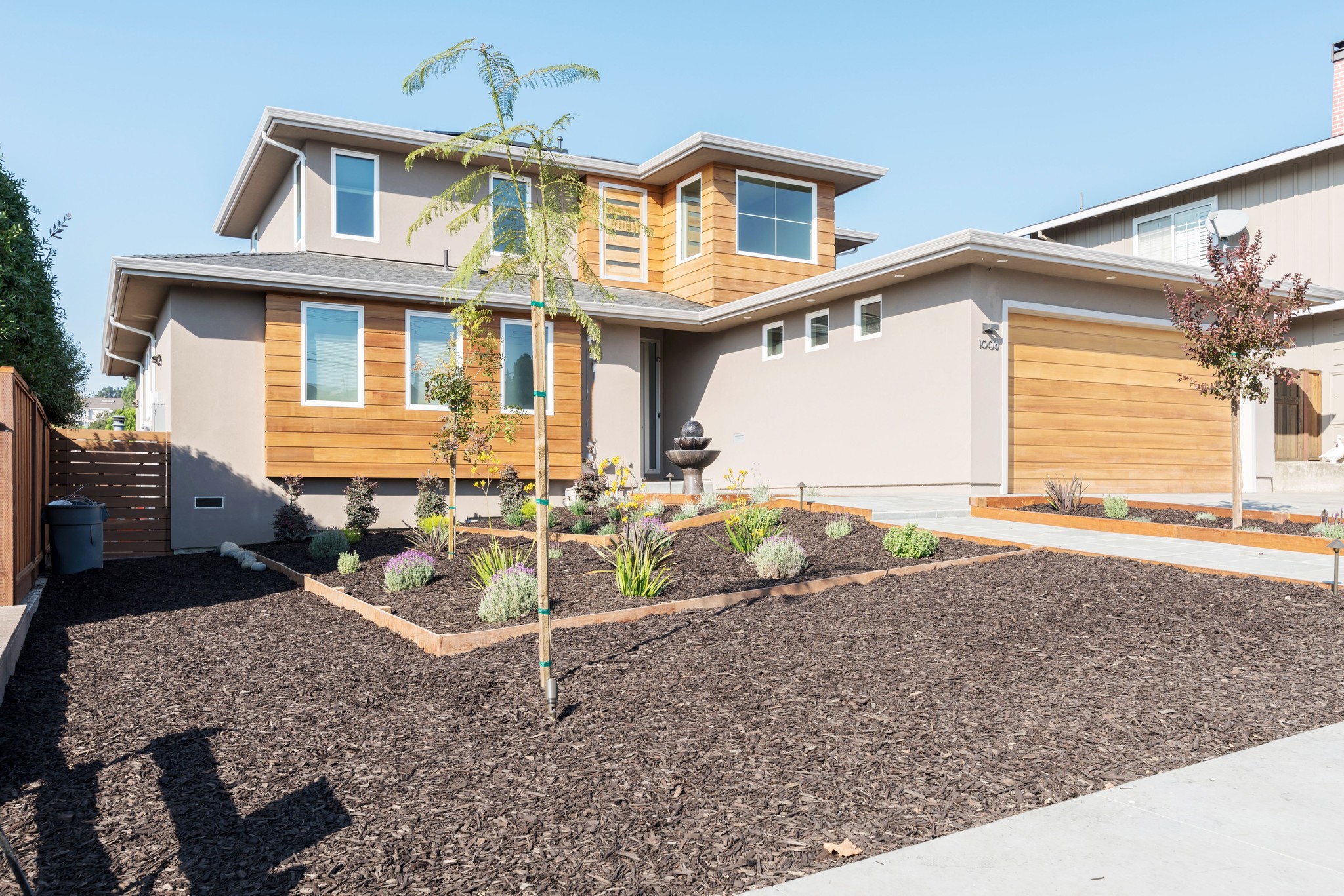 Two-story house with wood siding accents and a landscaped front yard.
