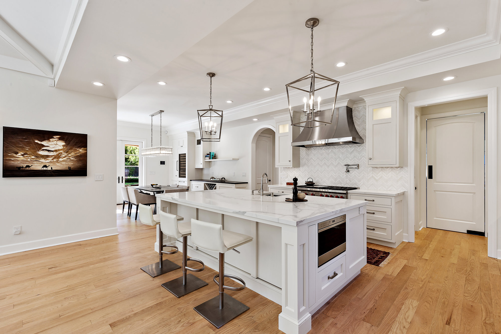 White kitchen with two islands and pendant lights in an Atherton home.