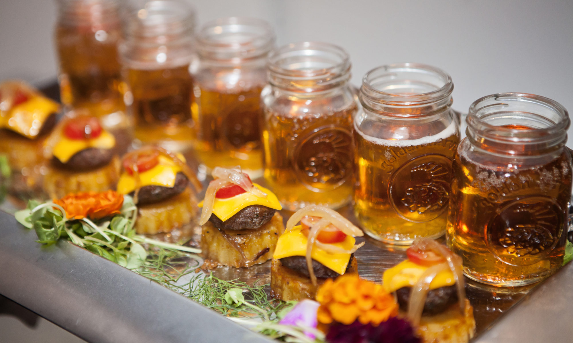 Mini cheeseburger sliders paired with mason jars of beer at a party