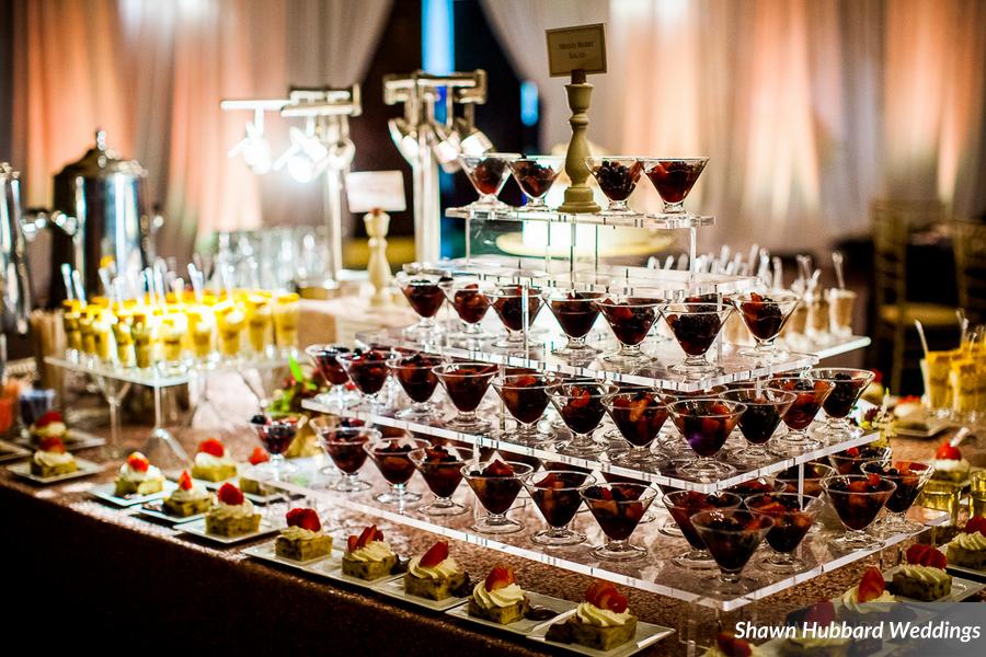 Wedding dessert display with tiers of mousse shots and mini desserts