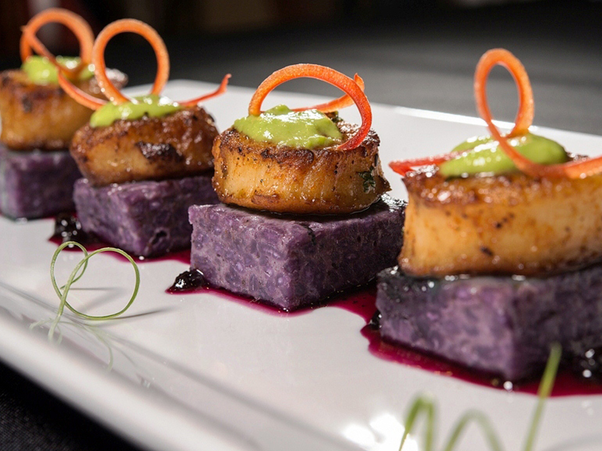 Seared scallops on purple potato cakes with carrot curls