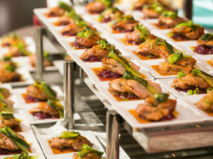 Rows of plated entrées lined up on serving racks