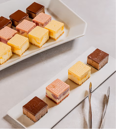 Layered dessert bars arranged on white platters