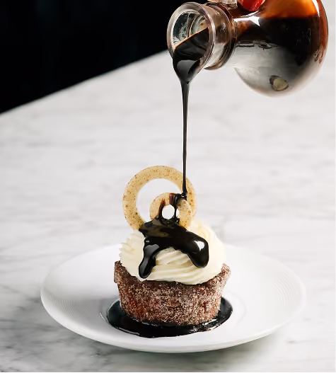 Chocolate sauce poured over a plated dessert