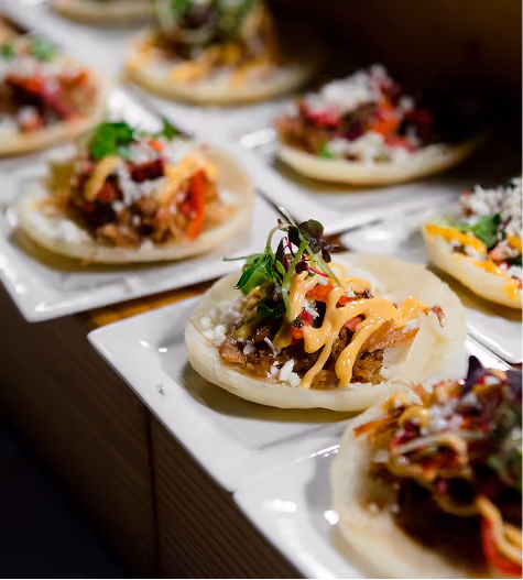 Mini tostadas with toppings and microgreens on white serving trays
