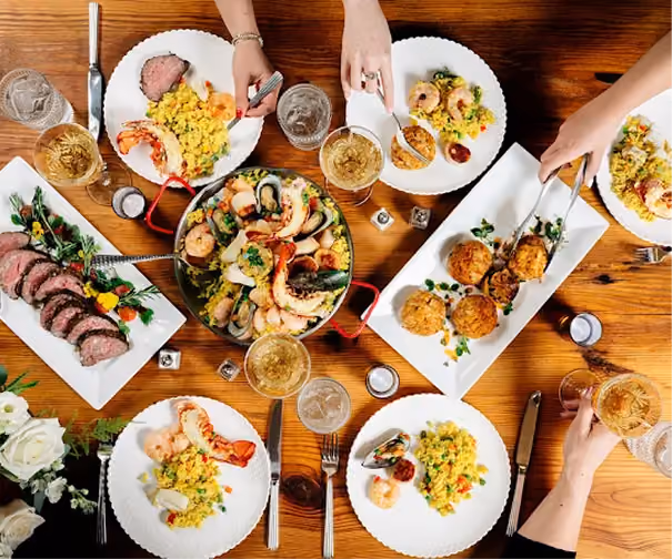 Guests sharing family-style dishes at a dinner table