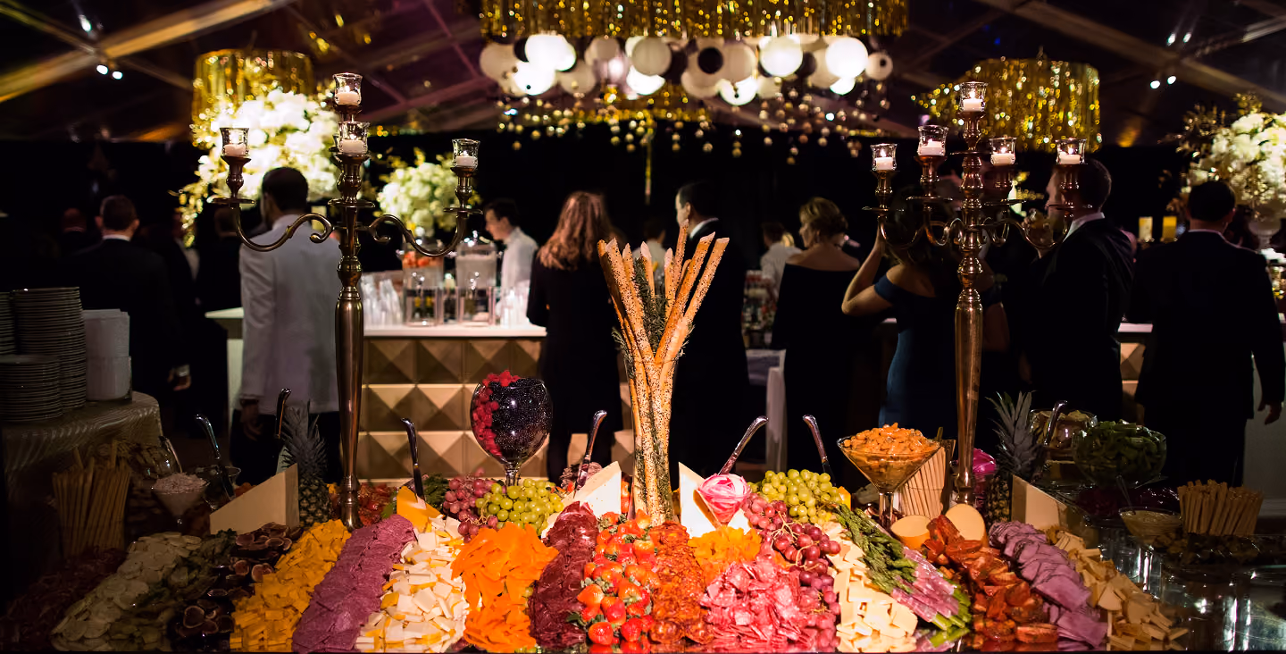 Guests mingling at an evening corporate event beside a large floral display
