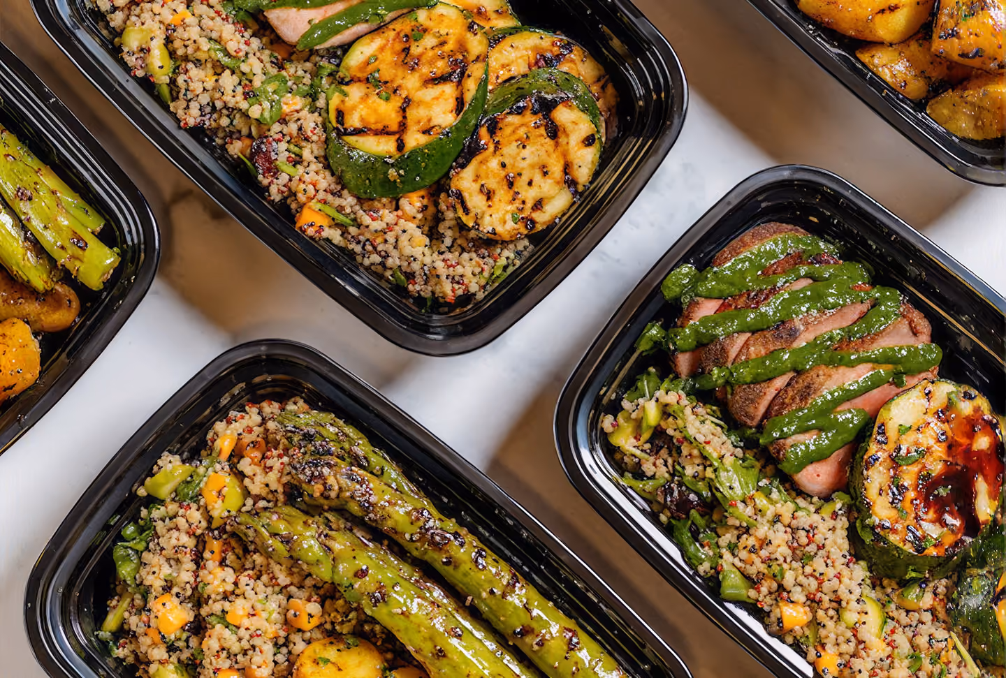 Boxed meals of grilled steak, quinoa and asparagus for office lunch catering