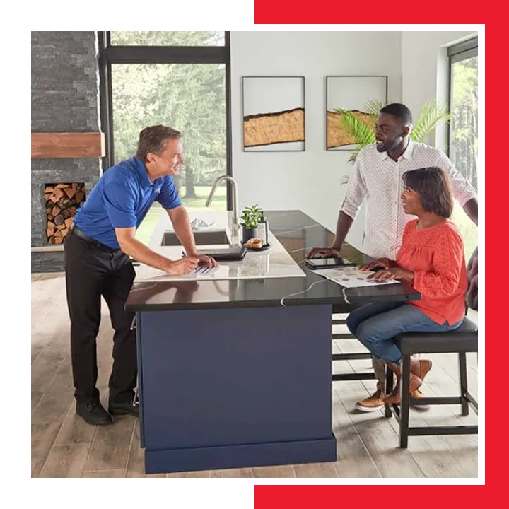 E.A.C. comfort advisor reviewing new system options with a couple at their kitchen island