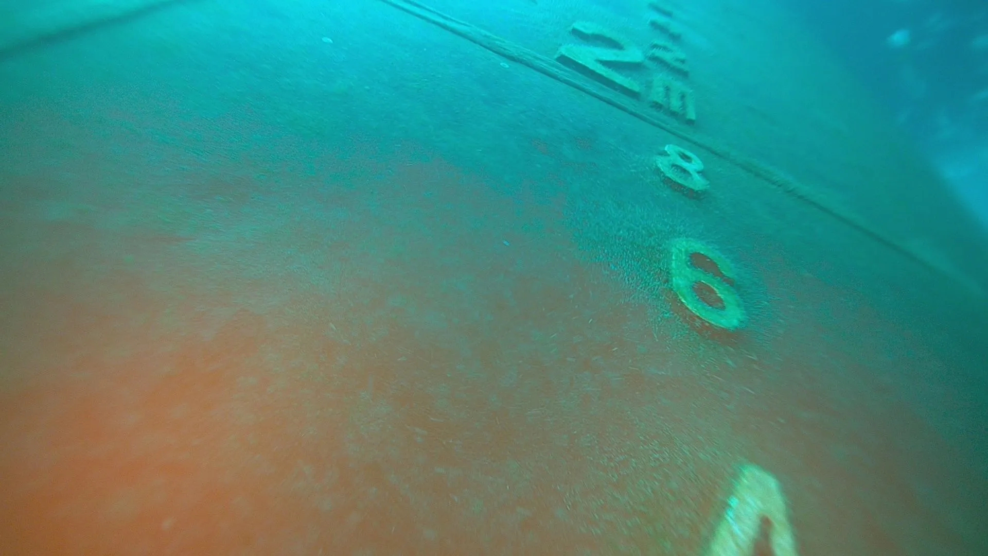 Underwater view of a ship's hull showing painted draft marks