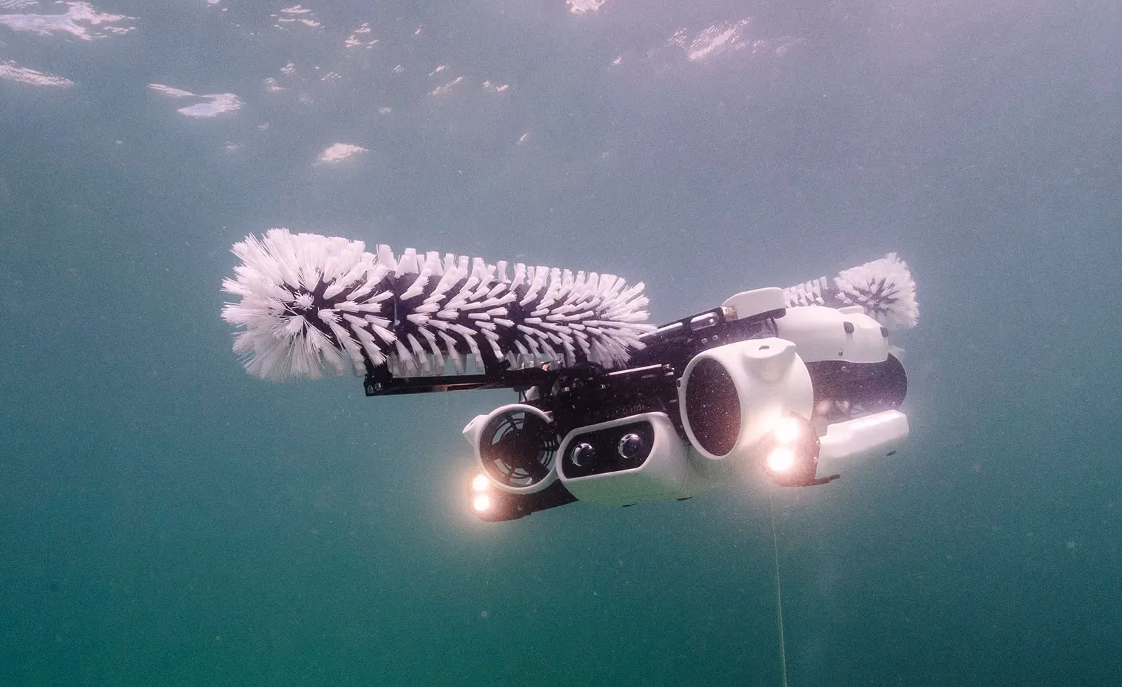 Hullbot robot swimming underwater with its brush arm extended