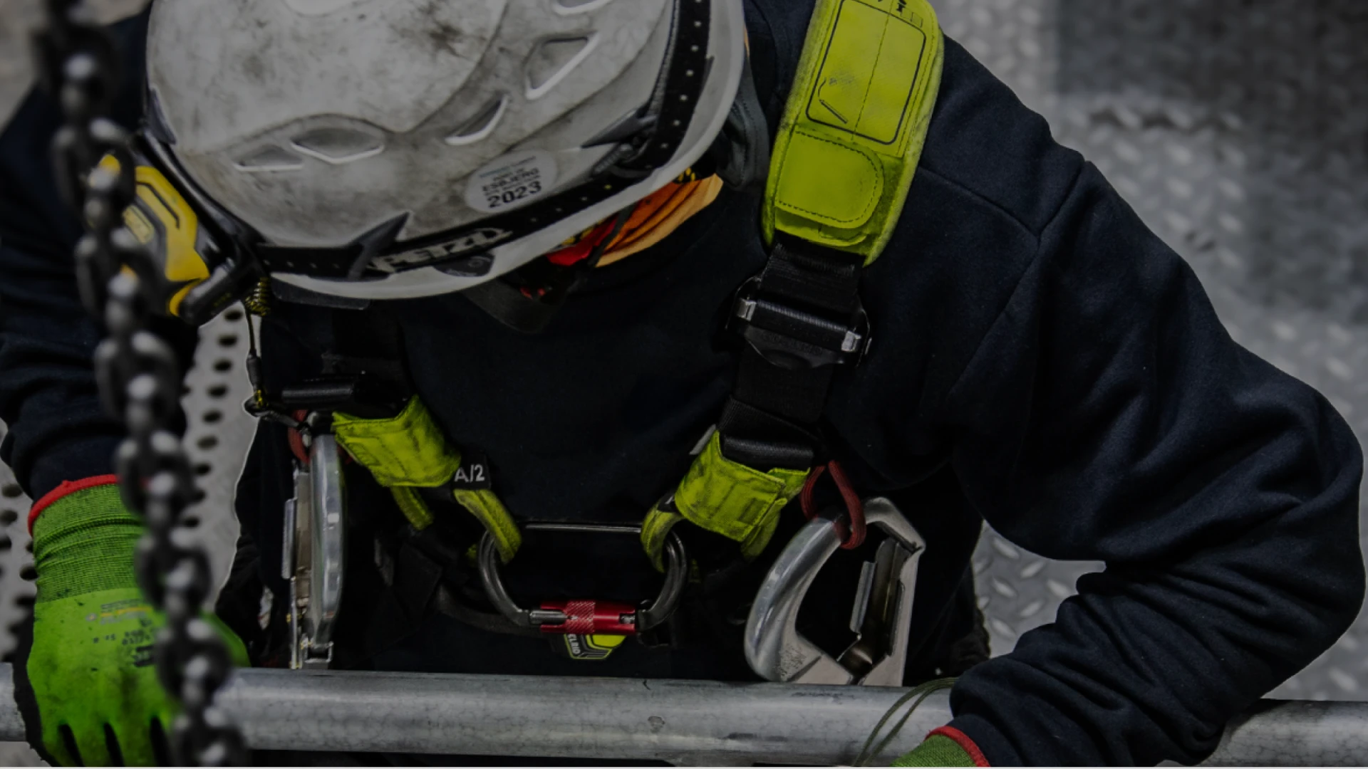 Technician in safety gear and harness working on a wind turbine