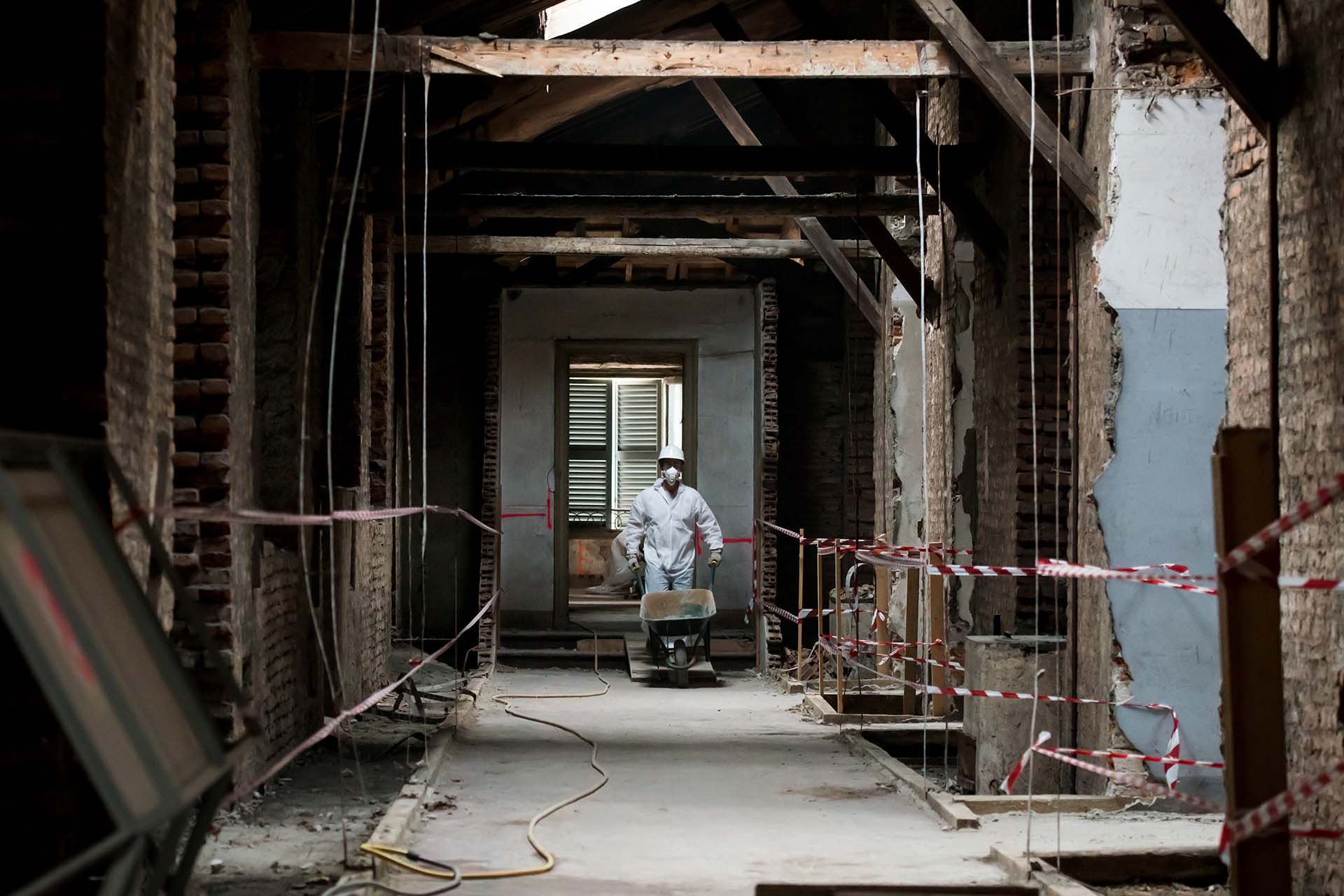 Chantier de réhabilitation balisé, intervenant en tenue de protection
