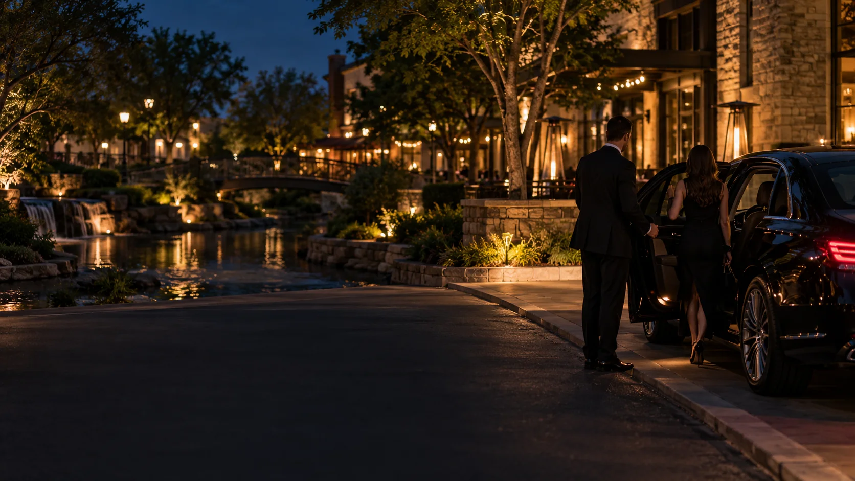 Chauffeur opening a car door for a client at a lantern-lit shopping village in Allen, Texas