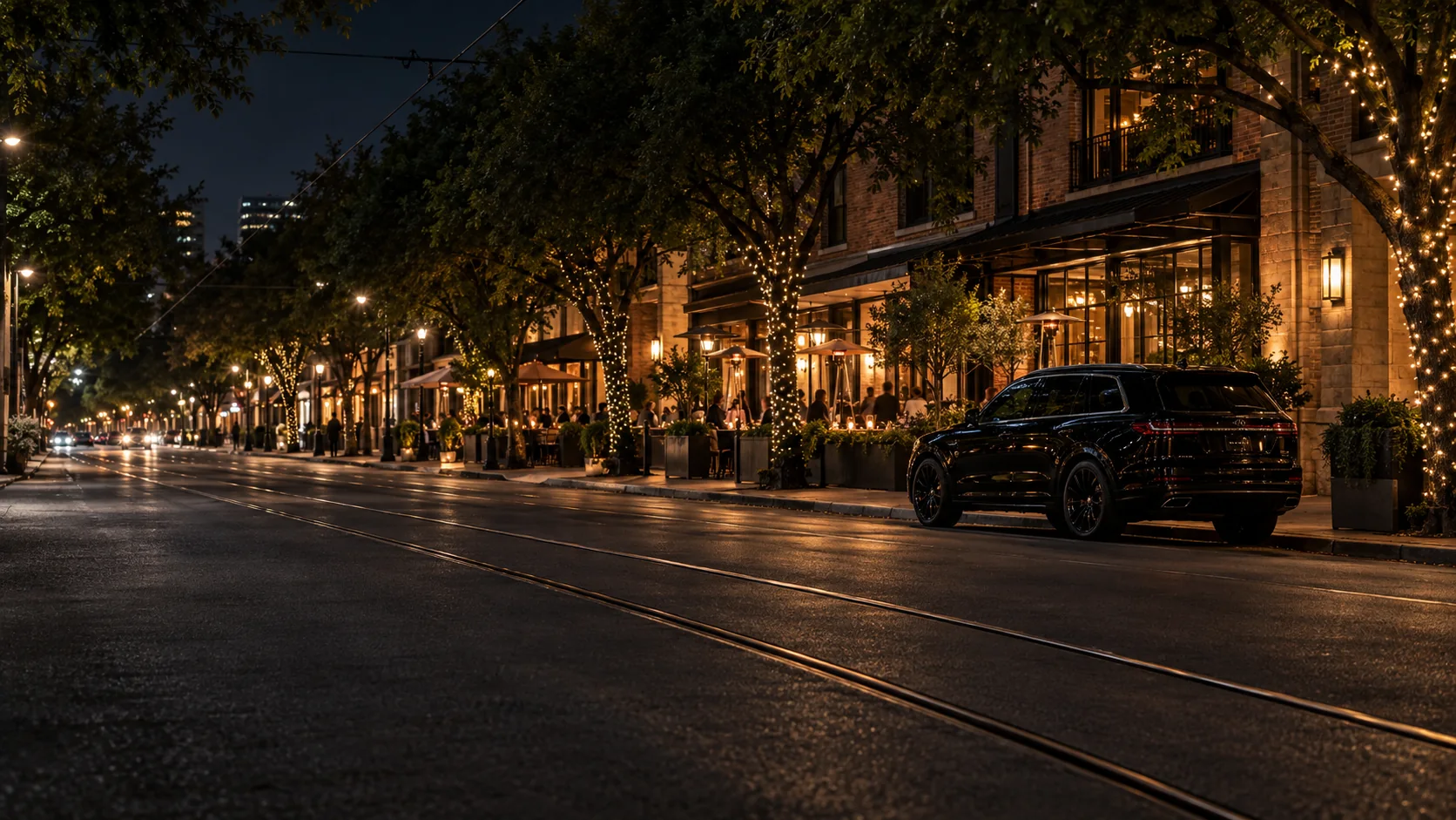 Black SUV black car service parked on McKinney Avenue in Uptown Dallas at night