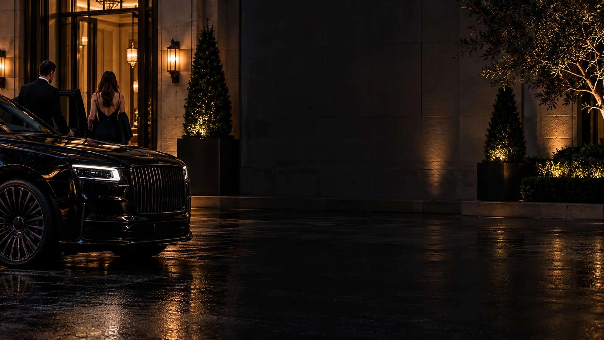 Black Rolls-Royce parked at a lit Dallas hotel entrance at night
