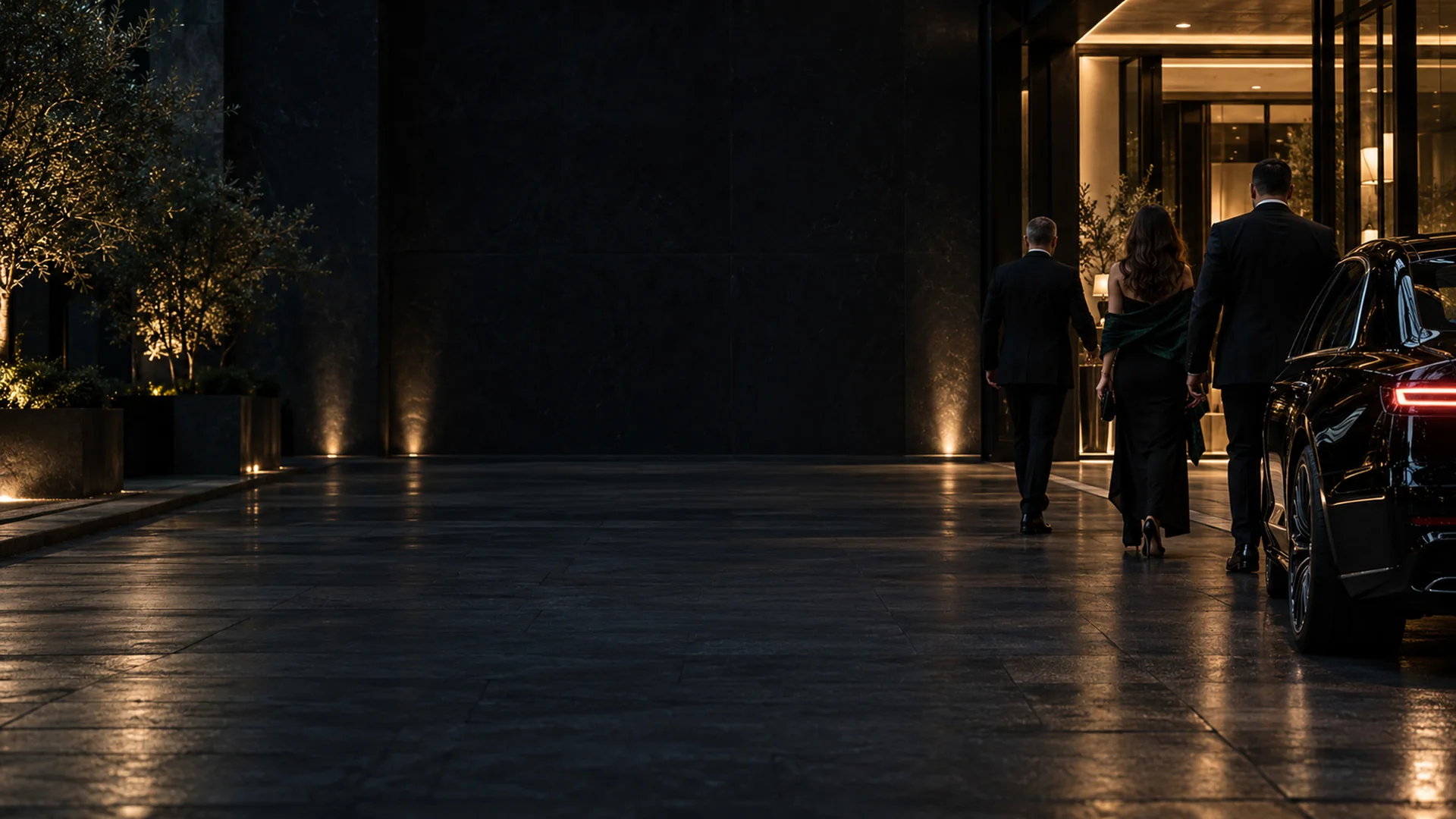 Executive protection team escorting clients into a Dallas building at night