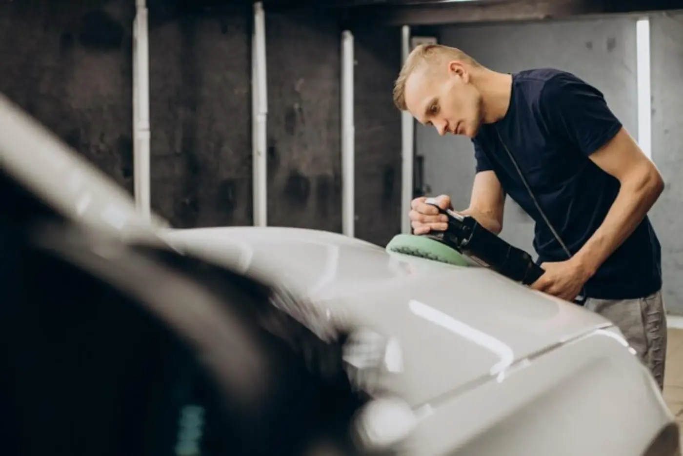 Car detailer polishing a white car