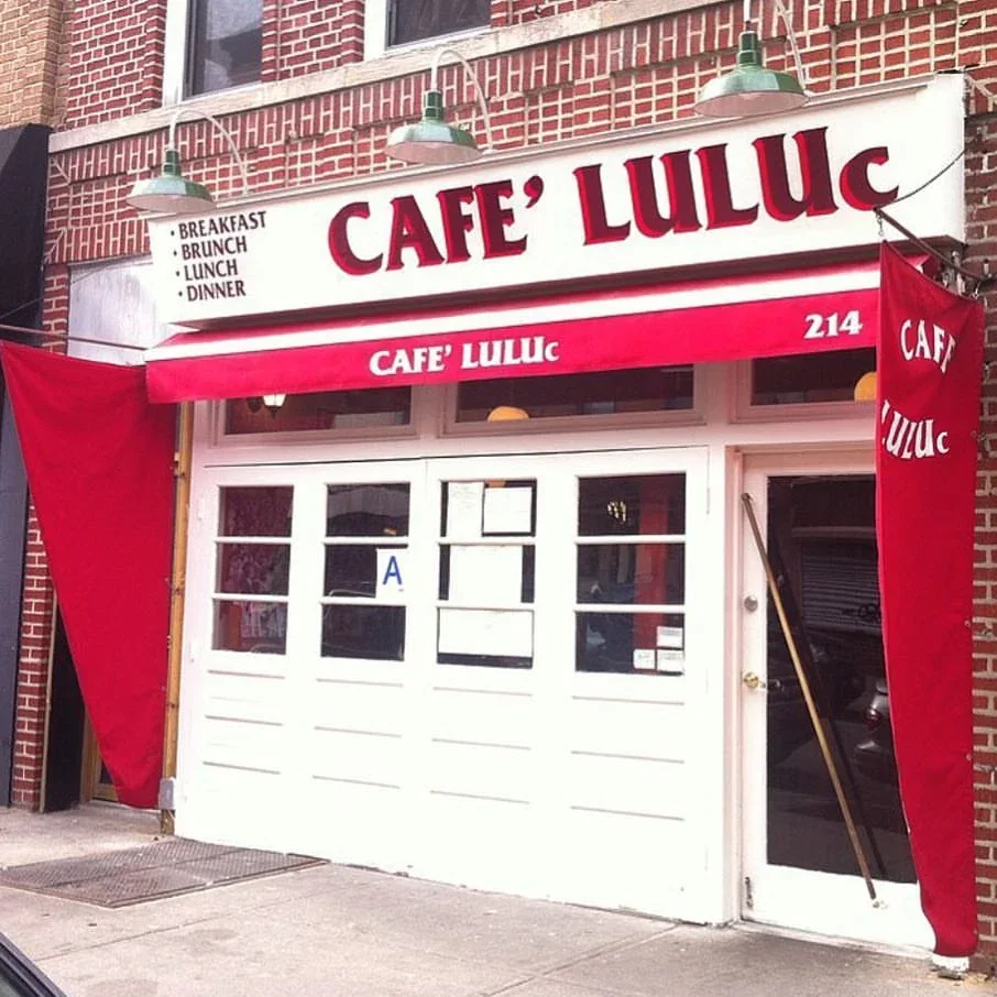 Café Luluc storefront with painted sign and red awning in Brooklyn