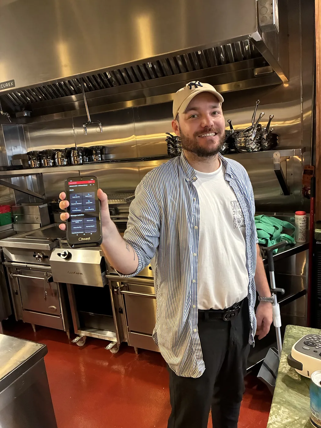 Straker's team member holding a Toast handheld device in the kitchen