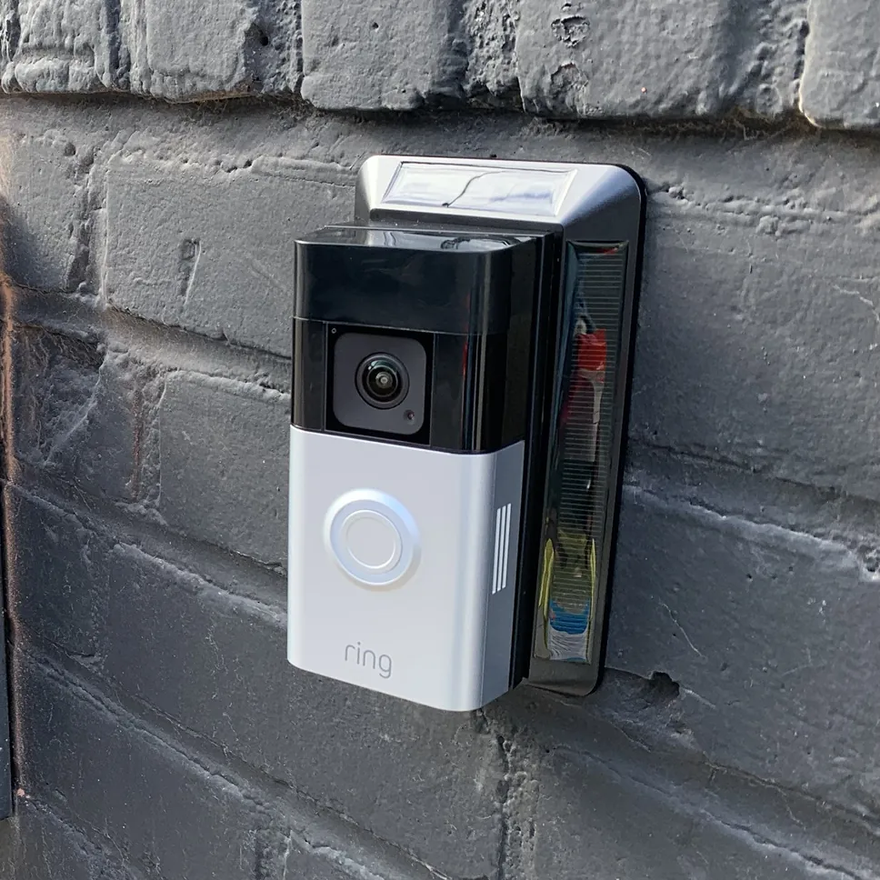 Video doorbell installed on a black brick entrance