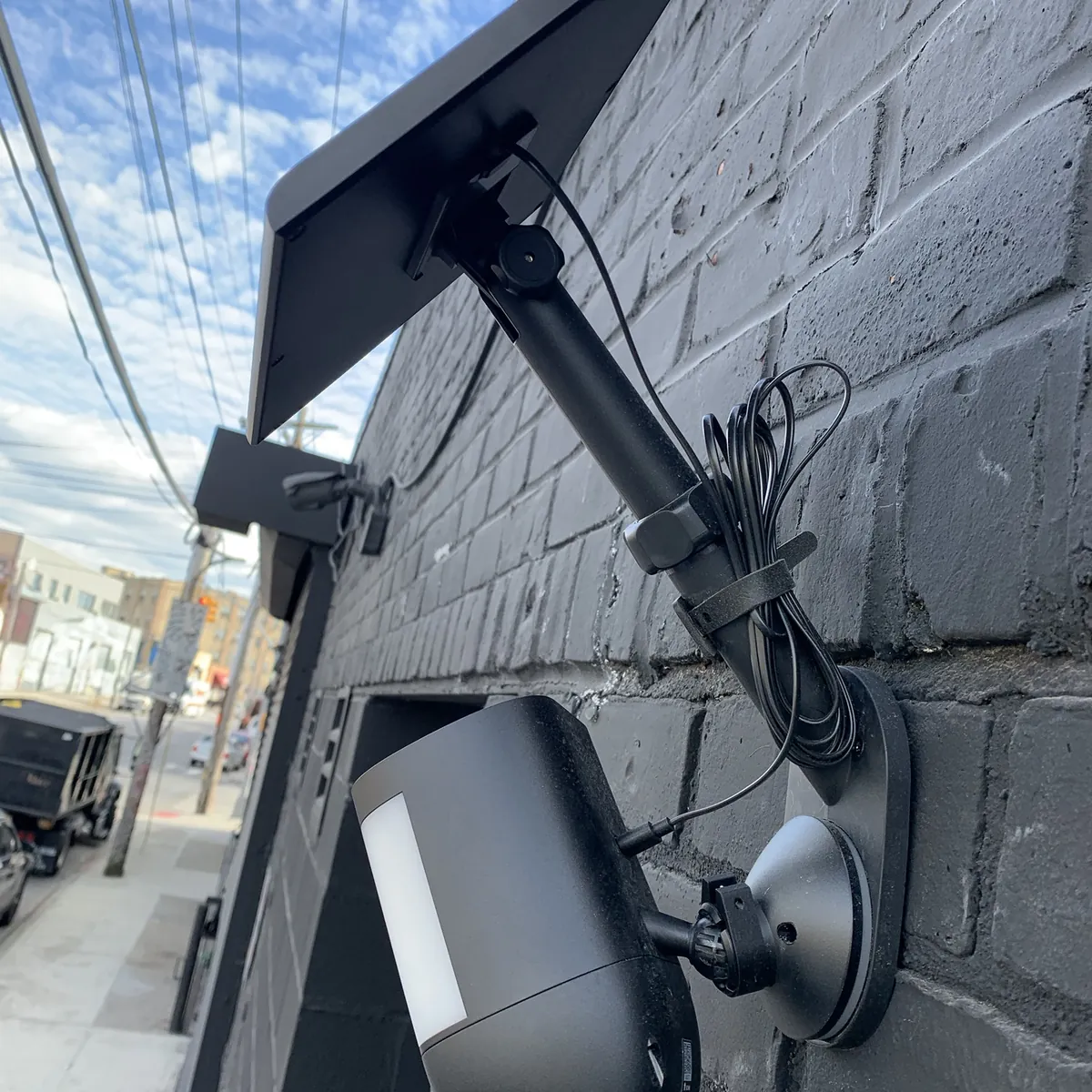 Exterior security cameras covering a storefront and sidewalk