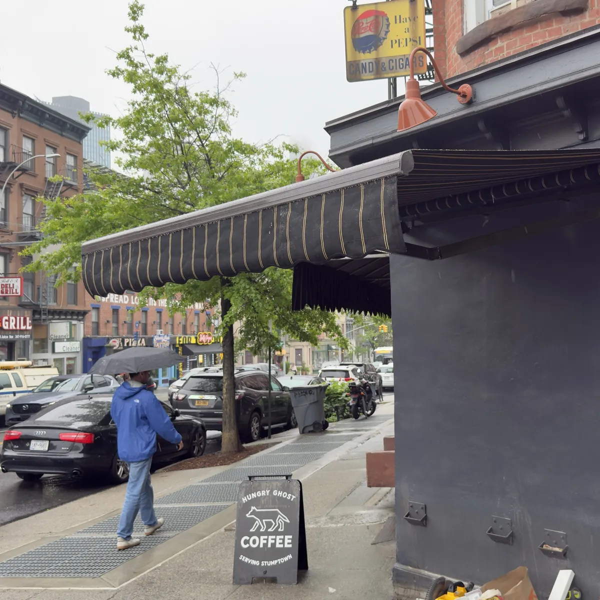 Striped retractable awning on the Hungry Ghost coffee shop corner in Brooklyn