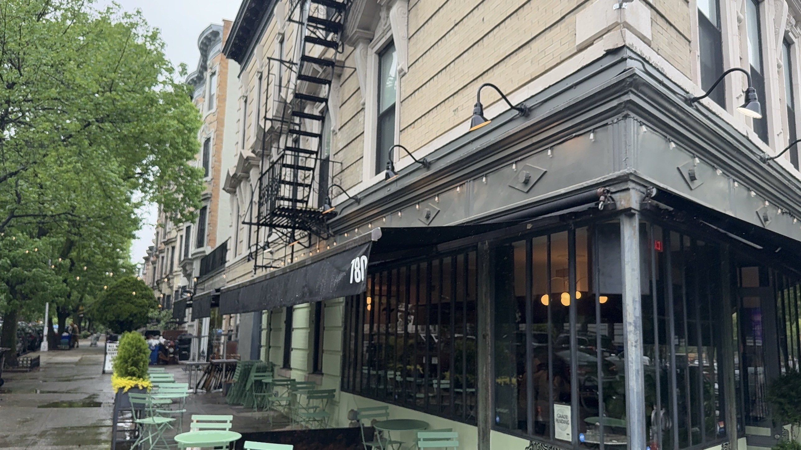 Black retractable awning with the 780 street number over the corner windows at Le Pistol Bar & Cafe