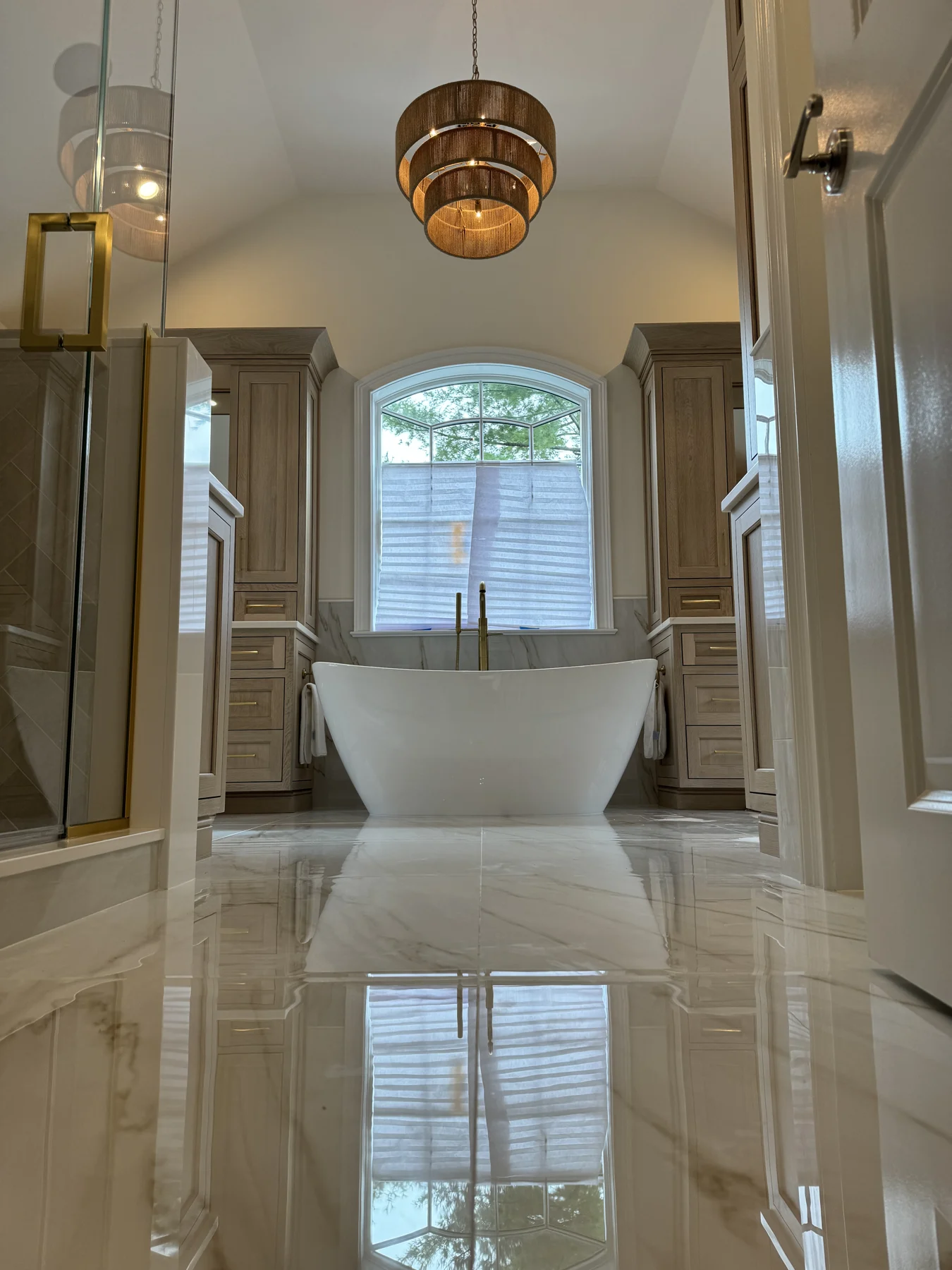 Primary bathroom with polished tile flooring and a freestanding tub