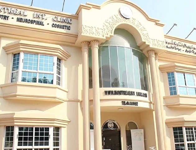 Facade of a beige building with classical columns and large arched glass windows above the entrance, showing signage for Montreal International Clinic specializing in dentistry, neurospinal, and cosmetic services, with the website www.montrealist.link and a contact phone number displayed.